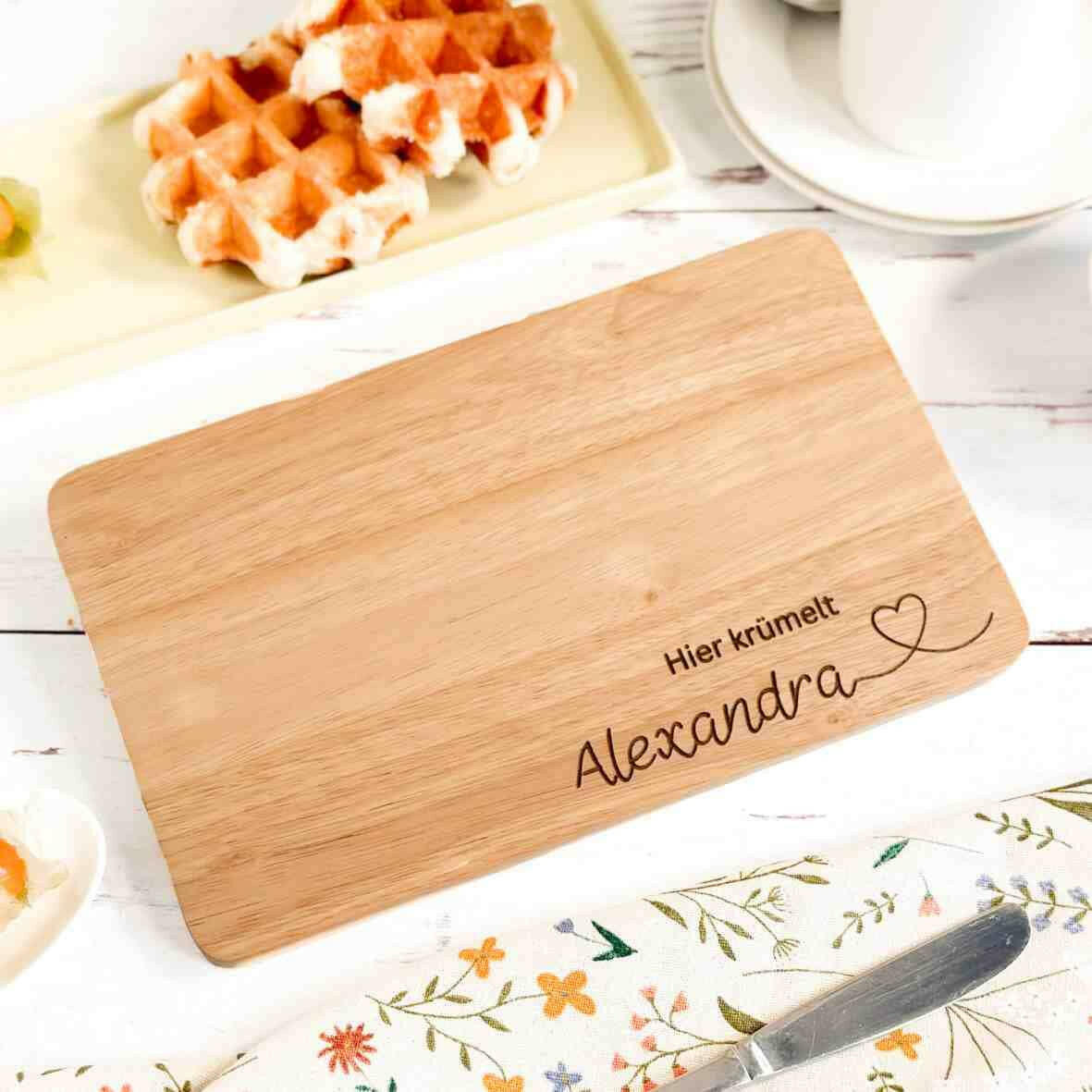 Personalisiertes Frühstücksbrettchen hier krümelt, mit Namen und Herz.