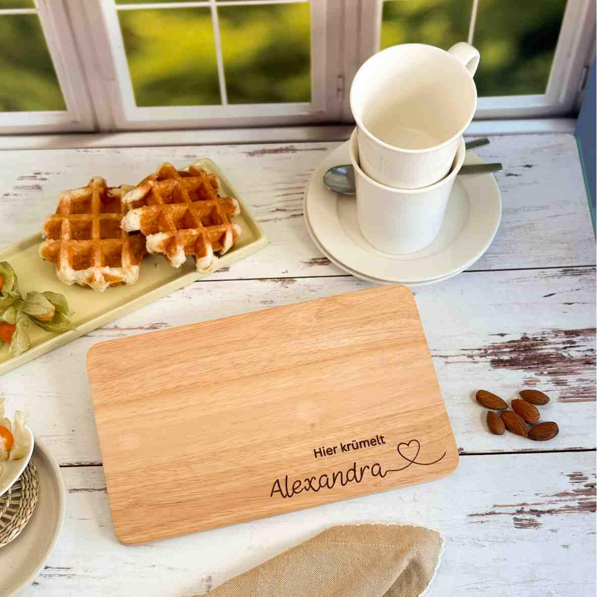 Personalisiertes Frühstücksbrettchen hier krümelt, mit Namen und Herz.