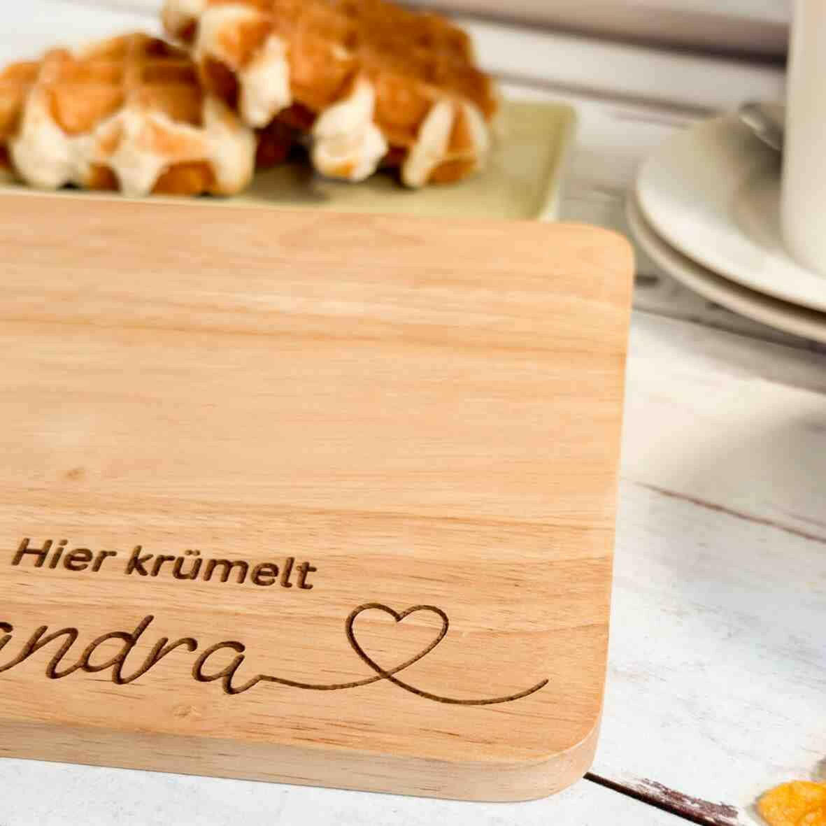 Personalisiertes Frühstücksbrettchen hier krümelt, mit Namen und Herz.