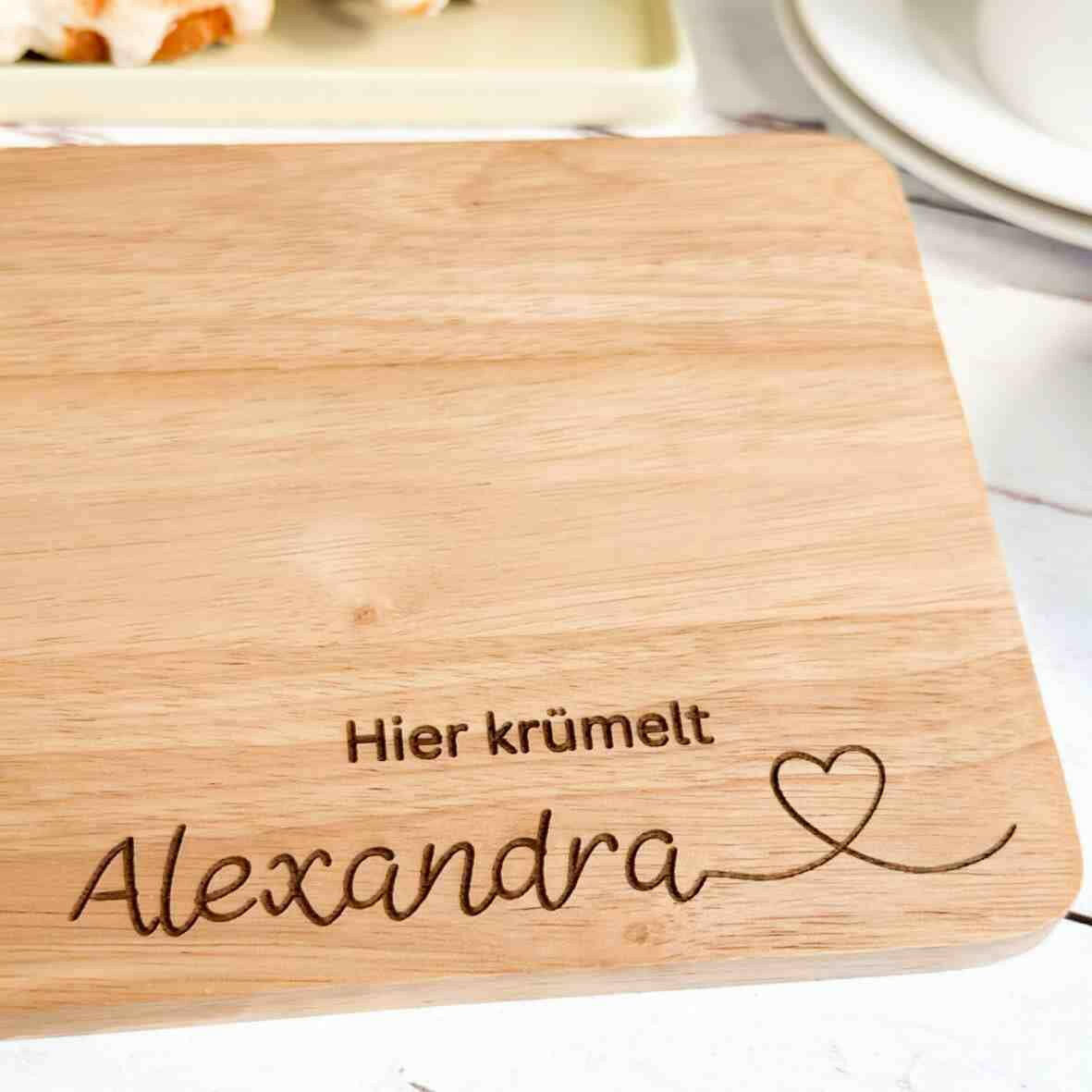 Personalisiertes Frühstücksbrettchen hier krümelt, mit Namen und Herz.