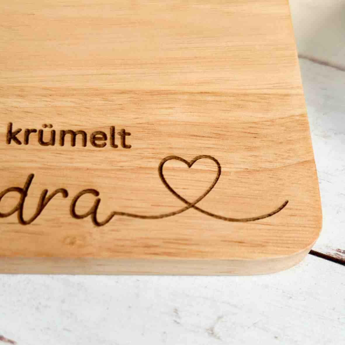 Personalisiertes Frühstücksbrettchen hier krümelt, mit Namen und Herz.
