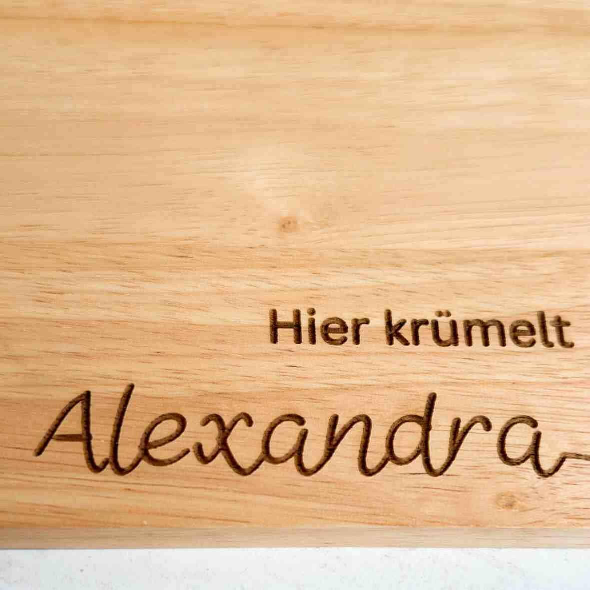 Personalisiertes Frühstücksbrettchen hier krümelt, mit Namen und Herz.