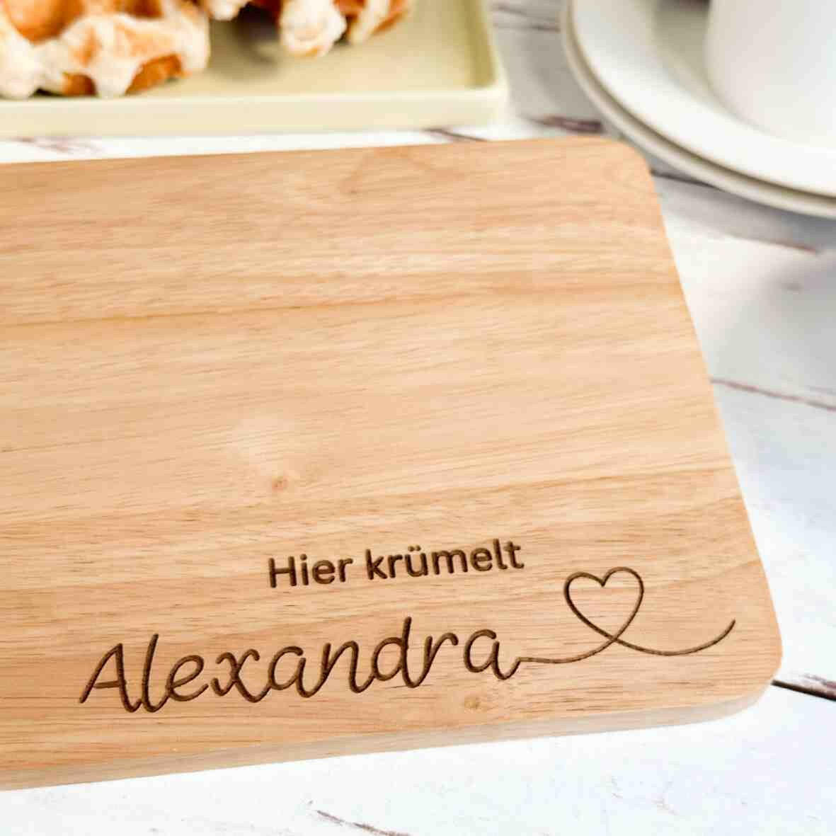 Personalisiertes Frühstücksbrettchen hier krümelt, mit Namen und Herz.