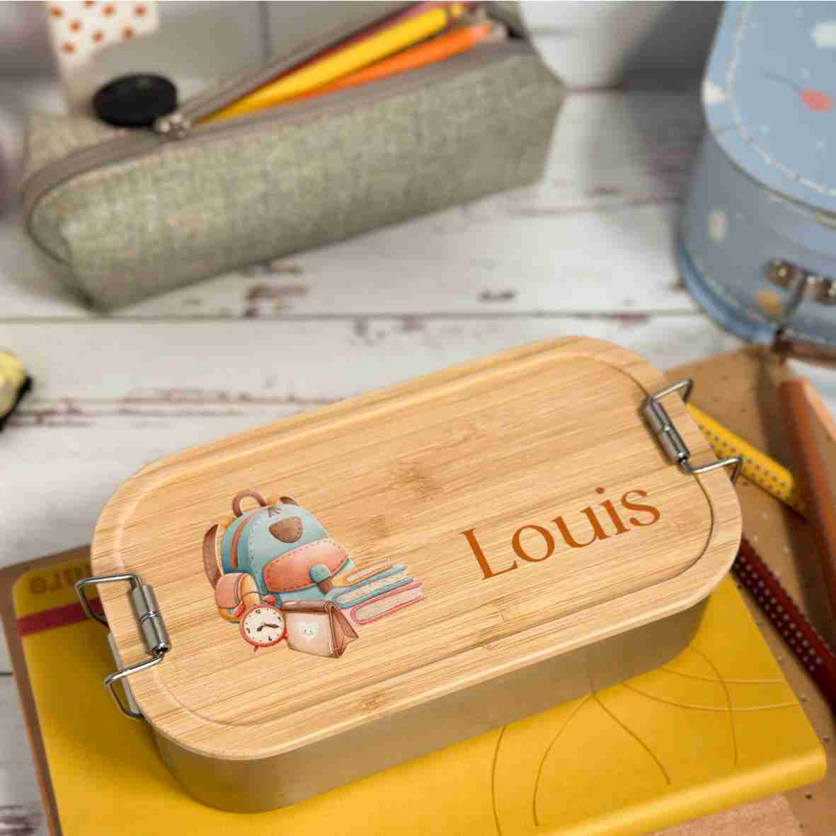 Personalisierte Brotdose aus Edelstahl mit Bambusdeckel, Schulrucksack-Motiv und Name „Louis“ – liebevolles Geschenk zur Einschulung.