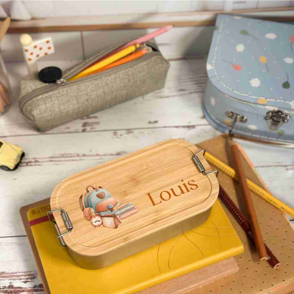 Personalisierte Brotdose aus Edelstahl mit Bambusdeckel, Schulrucksack-Motiv und Name „Louis“ – liebevolles Geschenk zur Einschulung.