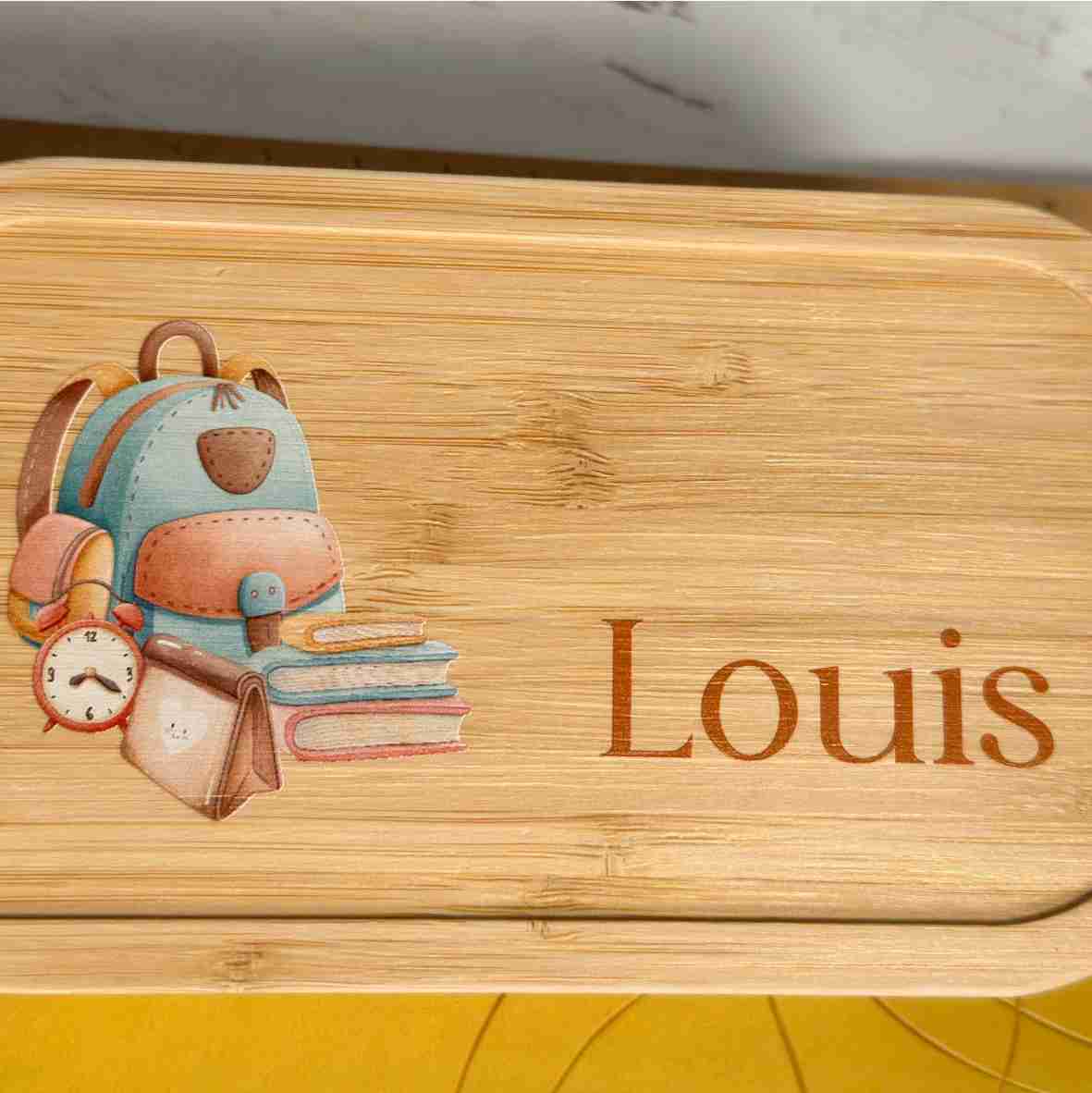 Personalisierte Brotdose aus Edelstahl mit Bambusdeckel, Schulrucksack-Motiv und Name „Louis“ – liebevolles Geschenk zur Einschulung.