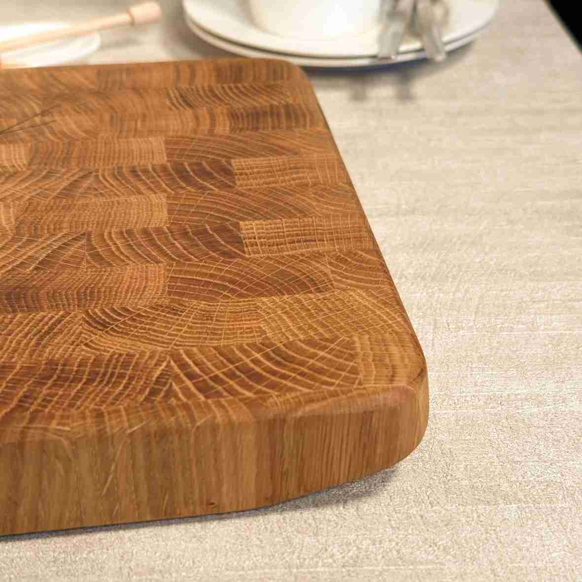 Personalisiertes Schneidebrett aus Eiche-Stirnholz mit gravierten Initialen „SM“, Namen „Sarah & Markus“ und Datum, als elegantes Hochzeitsgeschenk auf hellem gedecktem Tisch.