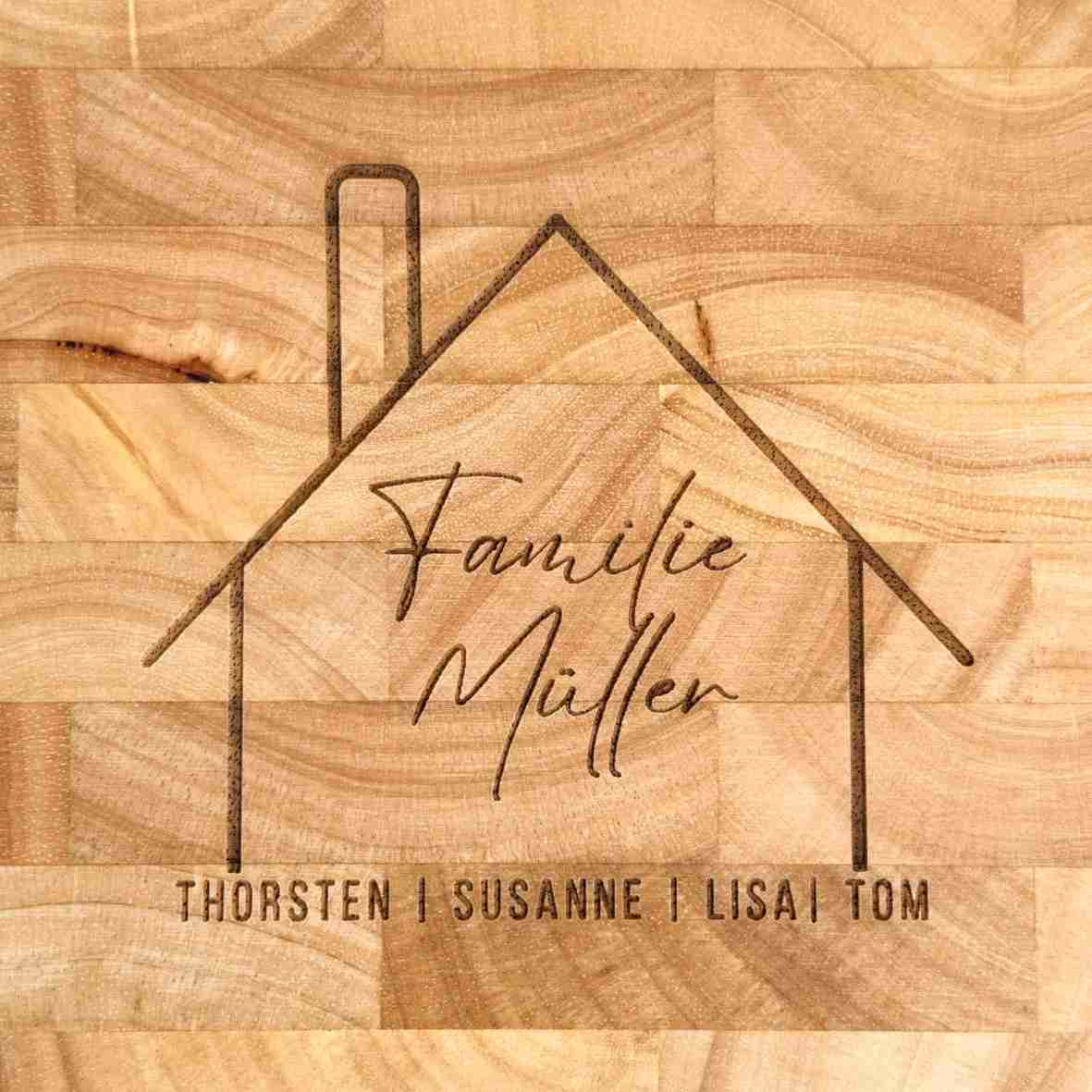 Graviertes Schneidebrett aus Stirnholz mit stilisierter Hausgrafik, Familiennamen „Familie Müller“ und den Vornamen aller Bewohner – Geschenkidee zum Einzug oder Hauskauf