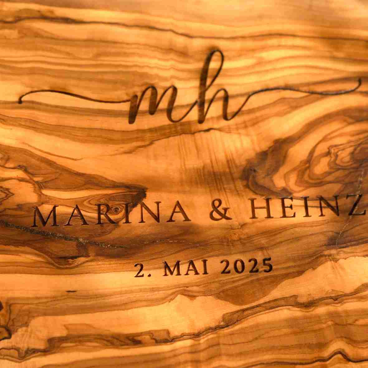 Graviertes Olivenholzbrett mit Initialen, Namen „Marina & Heinz“ und Datum „2. Mai 2025“ – personalisiertes Geschenk zur Hochzeit oder Einweihung.