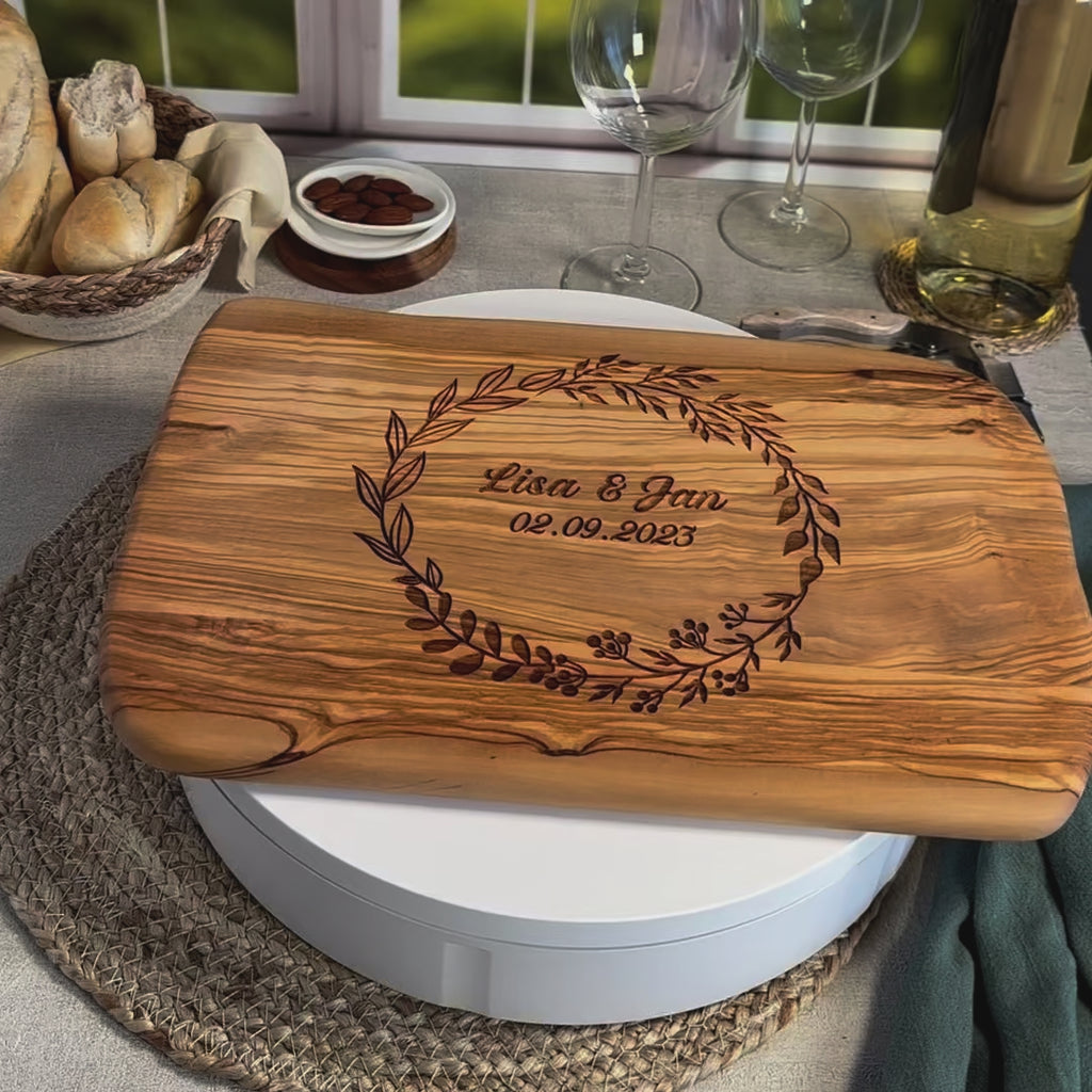 Personalisiertes Schneidebrett aus Olivenholz mit floralem Kranz, graviertem Namen „Lisa & Jan“ und Datum – romantisches Geschenk zur Hochzeit oder Verlobung.