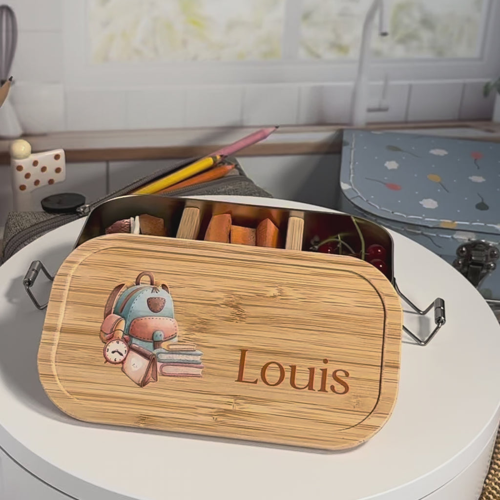 Personalisierte Brotdose aus Edelstahl mit Bambusdeckel, Schulrucksack-Motiv und Name „Louis“ – liebevolles Geschenk zur Einschulung.